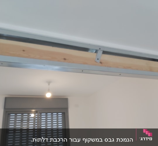 מסגרת מתכת עם לוח עץ בתקרה